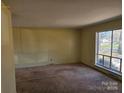 A bright living room with carpet, a large window offering ample natural light, and a neutral color scheme at 1608 Carfax Dr, Charlotte, NC 28216