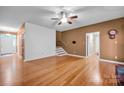Inviting living room features gleaming hardwood floors, ceiling fan and staircase at 161 Picwyck Dr, Mooresville, NC 28115