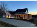 Farmhouse exterior, expansive porch, driveway, and landscaping at 243 Reese Wilson Rd, Belmont, NC 28012