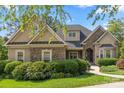 Detailed close-up of exterior displaying stone and stucco facade, lush landscaping and manicured lawn at 4150 Summit Ridge Ln, Denver, NC 28037