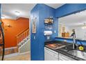 Kitchen with blue walls, white cabinets, and a black countertop at 4291 Melrose Club Dr, Matthews, NC 28105