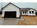Modern farmhouse exterior with a black garage door at 440 Steeplechase Trl, Salisbury, NC 28144