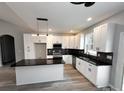 Modern kitchen with white cabinets, black countertops, and stainless steel appliances at 440 Steeplechase Trl, Salisbury, NC 28144