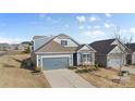 Two-story home with gray siding, two-car garage, and driveway at 5007 Grand Champion Ct, Iron Station, NC 28080