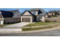 Two-story house with brown garage door, visible neighbors, and curved street at 1033 12Th Avenue Nw Dr, Hickory, NC 28601