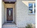 Dark brown front door with oval glass window and brick entryway at 1033 12Th Avenue Nw Dr, Hickory, NC 28601