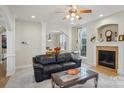 Cozy living room with a fireplace, ceiling fan, and neutral tones, flowing into an adjacent dining area at 13123 Meadowmere Rd, Huntersville, NC 28078