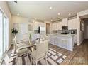 Modern kitchen with island, white cabinets, and glass dining table at 1412 Windy Park Dr, Stanley, NC 28164