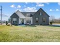 Modern farmhouse exterior boasts gray brick, white accents, and a charming front porch at 3436 Greene Rd, Monroe, NC 28110