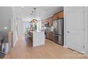 Beautiful kitchen with stainless steel appliances, oversized island, pendant lighting, and hardwood floors at 5632 Kingspan Dr, Charlotte, NC 28217