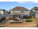 Aerial view of a spacious backyard featuring a patio, outdoor kitchen, putting green, and manicured landscaping at 14004 Fiery Mist Way, Huntersville, NC 28078