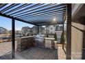 Outdoor kitchen with a built-in grill, countertop, and pergola, ideal for outdoor cooking and gatherings at 14004 Fiery Mist Way, Huntersville, NC 28078