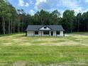 A charming one-story home with a fresh green lawn, complemented by a backdrop of lush trees at 2227 Charlotte Hwy, York, SC 29745