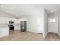 Modern kitchen with white cabinets, stainless steel appliances, and LVP flooring at 4119 Pebblebrook Sw Cir, Concord, NC 28027
