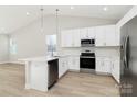 Bright kitchen with white cabinets, stainless appliances, island, and window at 4119 Pebblebrook Sw Cir, Concord, NC 28027