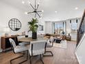 Open-concept dining area with a modern chandelier, sleek table set, and hardwood flooring throughout at 5715 Castlerea Dr, Charlotte, NC 28217