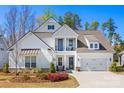 Beautiful two-story home featuring a two car garage, manicured lawn, and second-story balcony at 7150 Irongate Dr, Indian Land, SC 29707