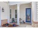 Charming front porch adorned with bistro set and vibrant flowers at 7150 Irongate Dr, Indian Land, SC 29707