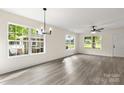 Open-concept living room with ample natural light, modern chandelier, and beautiful wood-look vinyl flooring at 939 Stonewall S Ave, Rock Hill, SC 29730