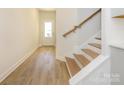 Bright hallway with light wood floors and a staircase leading to the upper level at 113 Quartz Hill Way, Waxhaw, NC 28173