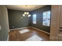 Simple dining room with dark green walls, light wood floors, and a chandelier at 135 Ella Claire Dr, York, SC 29745