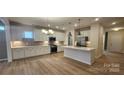 Open kitchen with white cabinets, quartz island, stainless steel appliances, and subway tile backsplash at 135 Ella Claire Dr, York, SC 29745