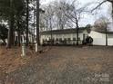 Exterior of a single story home with a gravel driveway at 135/137 Indian Harbor Trl # E16/17, Mount Gilead, NC 27306