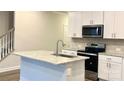 Modern kitchen with white cabinets, granite island, and stainless steel appliances at 3580 Backwater St, Concord, NC 28027