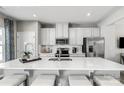 Modern kitchen with white cabinets, quartz countertops, and stainless steel appliances at 413 Serenity Cir, Cramerton, NC 28032