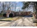 Ranch home with driveway, landscaping, and partial view of wooded area at 4918 Addison Dr, Charlotte, NC 28211