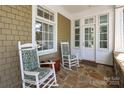 Inviting front porch with stone flooring and white rocking chairs for relaxed outdoor living at 1333 Carlton Ave, Charlotte, NC 28203