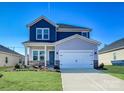 Two-story home with blue and gray siding, a two-car garage, and landscaping at 1515 Harper Landing Blvd, Stanley, NC 28164
