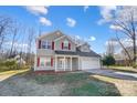 Two-story house with gray siding, red shutters, and a white garage door at 4603 Babbling Brook Ct, Indian Trail, NC 28079