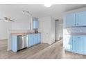 Kitchen with light blue cabinets, stainless steel appliances, and laminate flooring at 9321 Bayview Pkwy, Charlotte, NC 28216