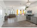 Bright, open-concept kitchen features white cabinetry, stainless steel appliances, and a large island with seating at 935 Mcalway Rd # 306, Charlotte, NC 28211