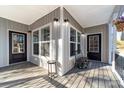 Side porch with two doors and a black bench at 360 Country Ridge Rd, Rockwell, NC 28138