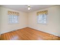 Bedroom with hardwood floors and two windows with window treatments at 644 Dogwood Rd, Statesville, NC 28677