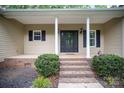 Inviting covered front porch with columns and a black front door at 1313 Western Hills Ln, Vale, NC 28168