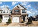 Two-story townhome with brick and siding exterior, two-car garage, and landscaping at 13417 Savannah Club Dr, Charlotte, NC 28273