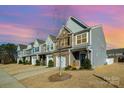 Townhomes with gray siding, two-car garages, and landscaping; sunset view at 13417 Savannah Club Dr, Charlotte, NC 28273