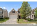 Two-story house with a white garage door and landscaping at 6107 Follow The Trl, Indian Trail, NC 28079
