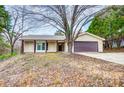 Tan one-story house with brown garage door and covered porch at 11015 Vista Haven Dr, Charlotte, NC 28226
