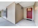 Red front door entry with a sidelight and dark brown shutters at 11015 Vista Haven Dr, Charlotte, NC 28226