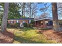 Brick ranch home with carport, mature trees, and a well-manicured lawn at 1108 Sewickley Dr, Charlotte, NC 28209