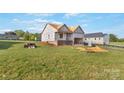 Exterior view of a new home build with large yard and partial brick facade at 149 Tranquility Ln, Harmony, NC 28634