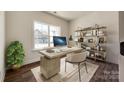 Bright office space with large window, modern desk, stylish shelves, and wood-look floors at 18011 Wilbanks Dr, Charlotte, NC 28278