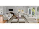 Spacious living room with an L-shaped sofa, hardwood floors, and large windows at 5204 Sardis Rd, Charlotte, NC 28270