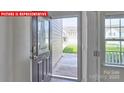 Front entry with glass-paned door and view of the front yard at 8024 Kennesaw Dr, Gastonia, NC 28056