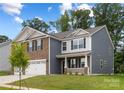 Charming two-story home with a brick and siding facade, well-maintained lawn and a two car garage at 8024 Kennesaw Dr, Gastonia, NC 28056