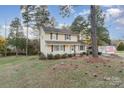 Two-story house with yellow siding, front porch, and landscaping at 9 Post Oak Pl, Salisbury, NC 28147